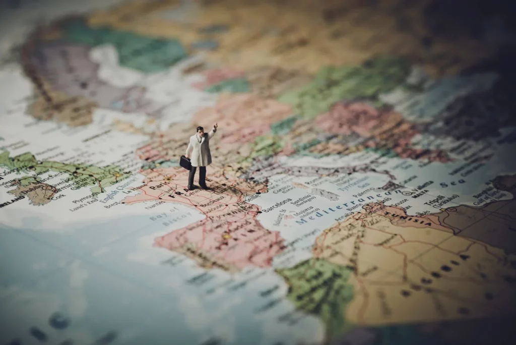 a little plastic human figure positioned on the country of france on a map 